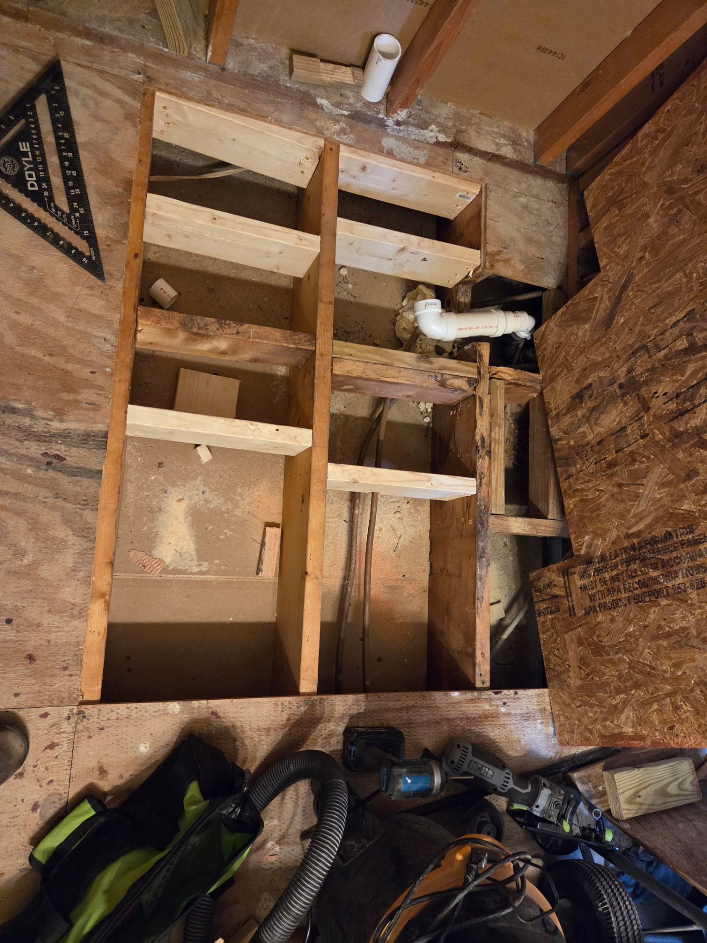 Subfloor opened up with new joists and plumbing rough-in for a bathroom remodel